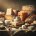 A sepia-toned still life photograph of various cheeses such as feta, cheddar, parmesan, arranged aesthetically on a rustic wooden table beside a loaf copy